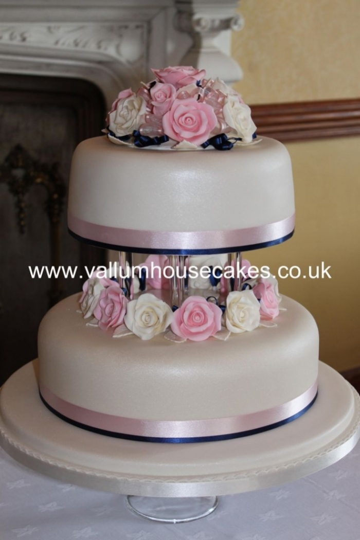 gâteau simple à 2 étages avec différentes fleurs avec rubans rose